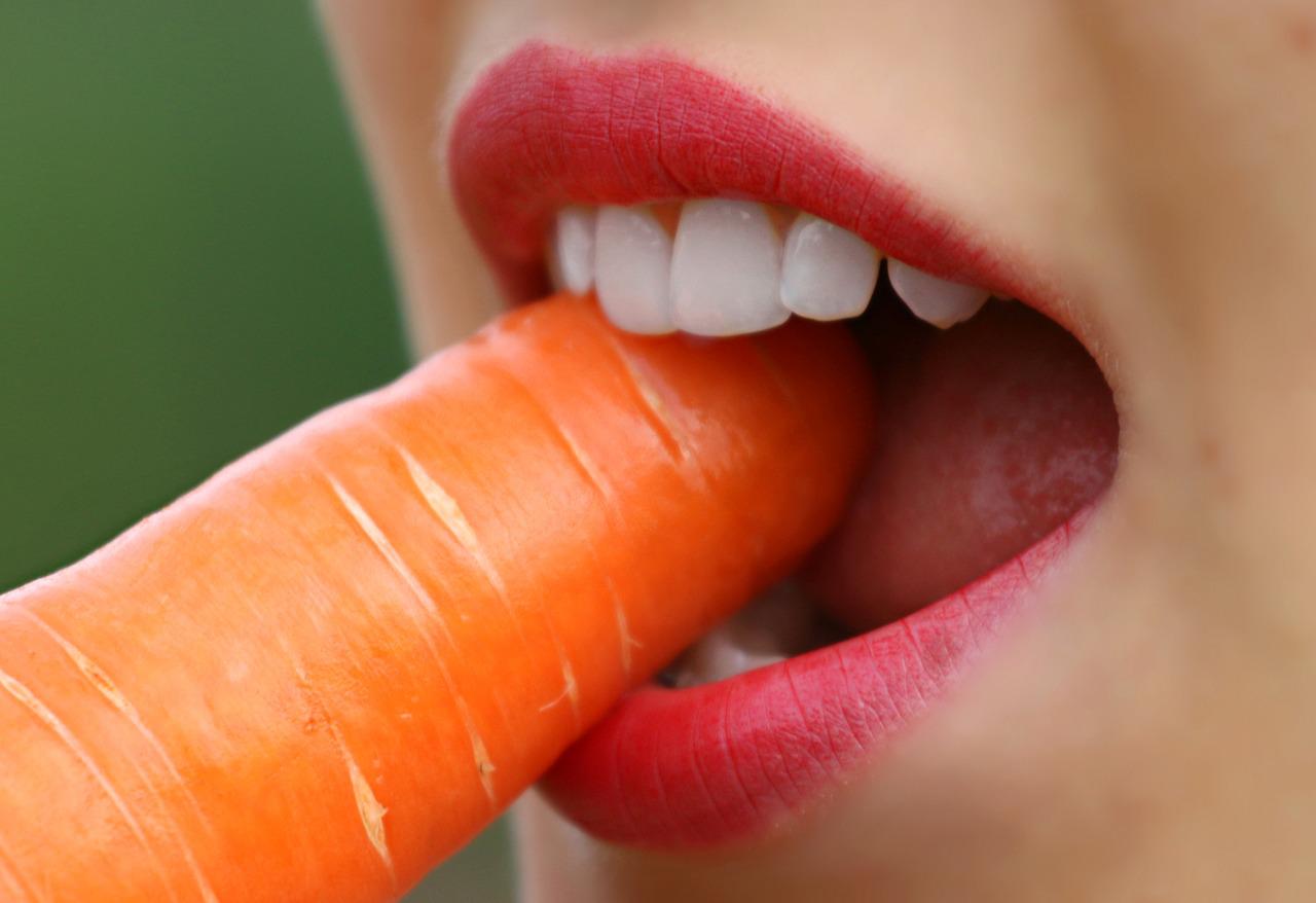 Kobieta gryzie marchewkę